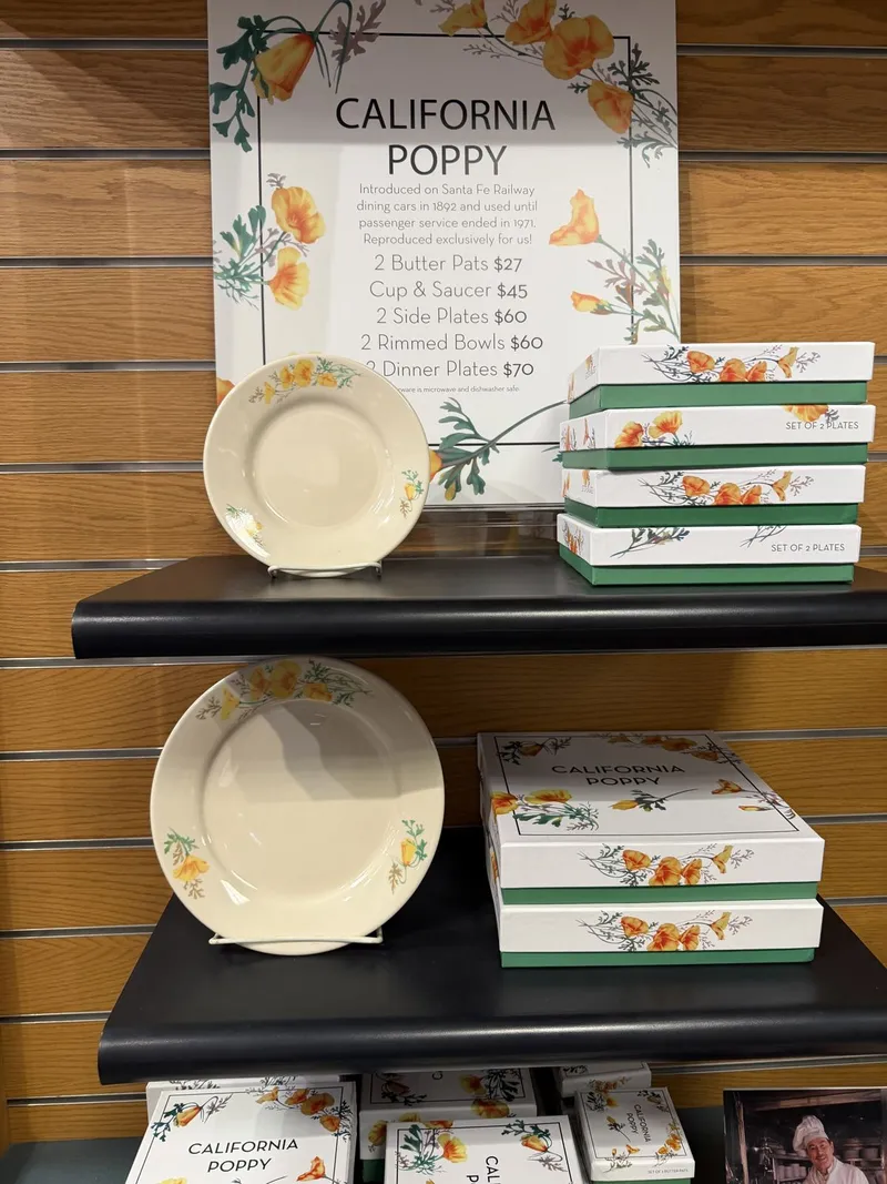Its Santa Fe counterpart: California Poppy, the pattern introduced on dining cars in 1892 and served until passenger service ended in 1971 — cream plates with orange poppies, boxed sets in green and white.